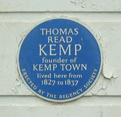 Shows a photograph of a blue plaque with white lettering, commemorating Thomas Read Kemp, who lived in the house. It reads: &#39; Thomas Read Kemp founder of Kemptown lived here from 1827 to 1837&#39;. Around the bottom, are the words: &#39;erected by the Regency Society&#39;.